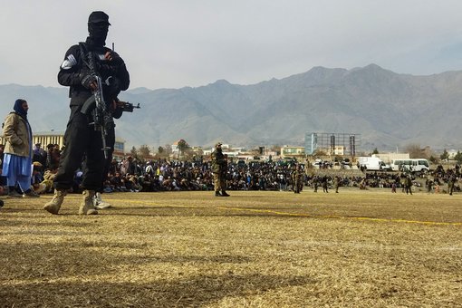 Ein Sicherheitsbeamter der Taliban steht Wache, während Menschen in einem Fußballstadion in der Stadt Charikar in der Provinz Parwan am 8. Dezember 2022 der öffentlichen Auspeitschung von Frauen und Männern beiwohnen. © AFP via Getty Images