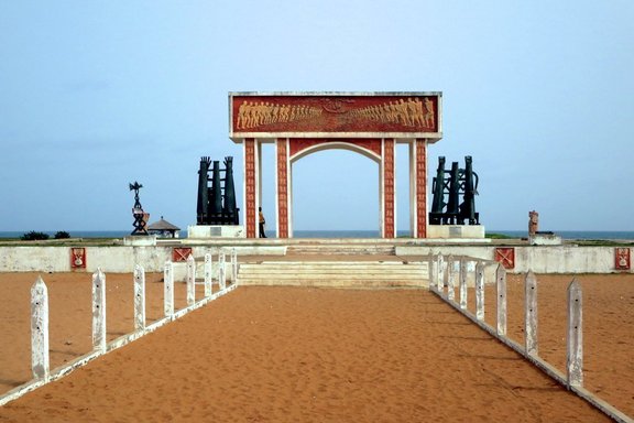 Zwölf Millionen Afrikaner_innen wurden von diesem Strand aus mit den Sklavenschiffen eingeschifft. Die Gedenkstätte Port de Non Retour (1995) markiert das Ende der vier Kilometer langen Route des Esclaves von Ouidah, Benin © "Port de Non Retour" by D-Stanley is marked with CC BY 2.0. To view the terms, visit https://creativecommons.org/licenses/by/2.0/?ref=openverse 